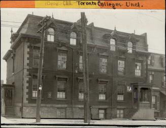 Three-storey brick structure with Mansard roof and dormer windows. 