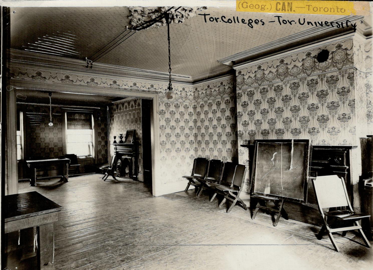 Interior of pass-through room with decorative wallpaper, hardwood floors and two mantels. Foldi…