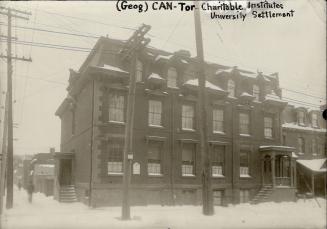 Three-storey brick structure with Mansard roof, dormer windows and small covered front entrance…