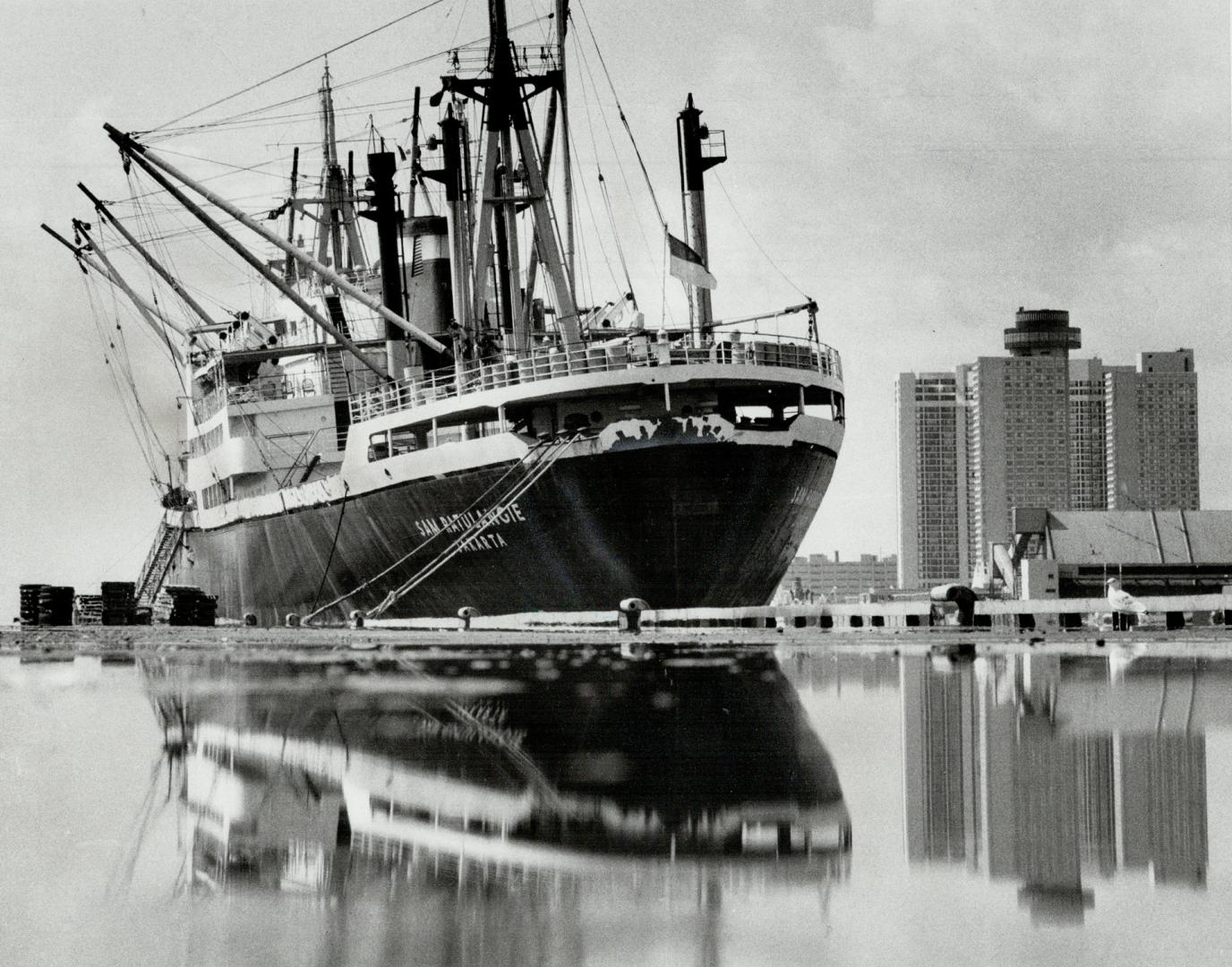 Image shows a huge ship on the lake with some waterfront buildings in the background.