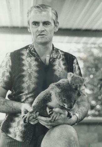 A mother and baby koala sit snuggly in a keeper's hands at the Lone Pine sanctuary near Brisbane, one of the few places in the world where visitors can not only see but hold the cuddly creatures