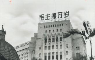 It's cheaper today for east to meet west in this tiny British colony where the plush Hilton Hotel and the Communist Bank of China are neighbors