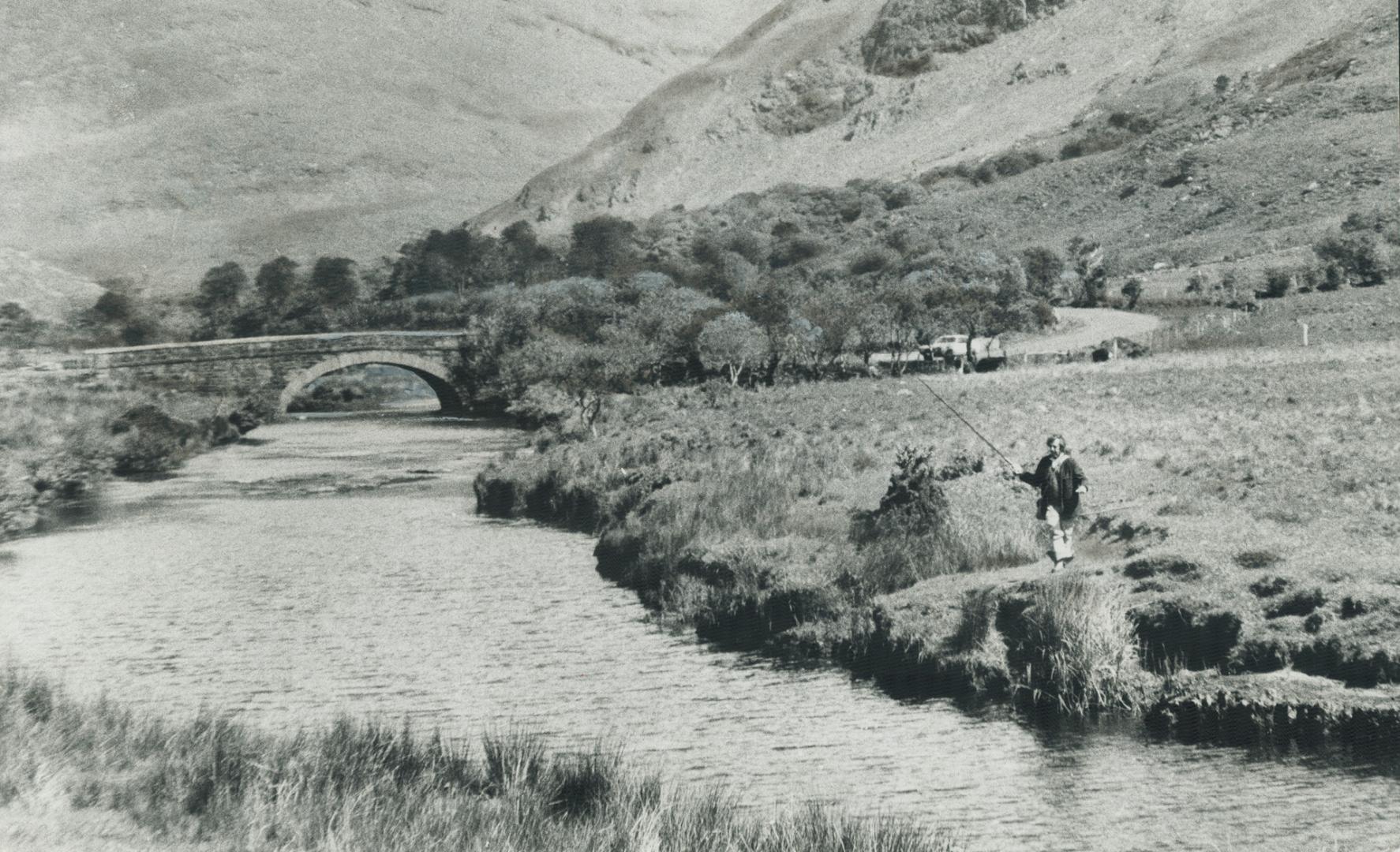 The hills of connemara loom above this quiet stream where a visitor wets his line and hopes for, if not a trophy, at least his dinner. Such peaceful g(...)