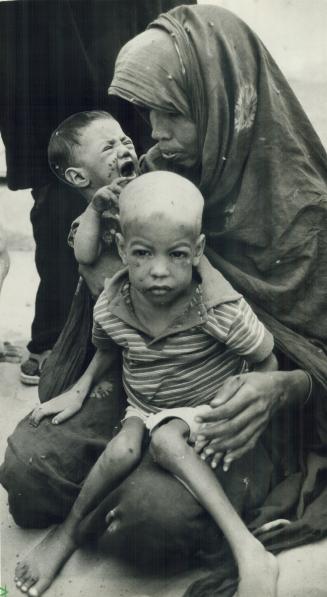 Fatal Famine. A mother waits with her starving children for food and medical help in drought - stricken Mauritania