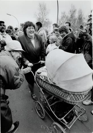 Welcome home: An East Berlin mother strolling with her baby to see the other side of their city is greeted by newfound neighbors