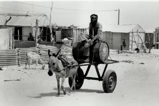 Making do: Water is hauled to the shanytown from where Rokhaya mint Salem, below, walked four kilometres to the clinic with her baby born just 24 hours earlier