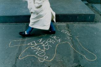 A Sunday stroller walks by Dead from lack of AIDS funds graffiti in Soho