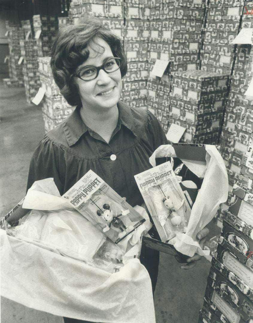 Truck loads of toys, candy and other goodies cram the secret warehouse where gnome Gail O'Sullivan packs Star Santa Claus fund gift boxes for delivery(...)