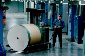 Learning the ropes: Gord Fowler tests the operation of an Automatic Guided Vehicle (AGV) as it moves a roll of newsprint