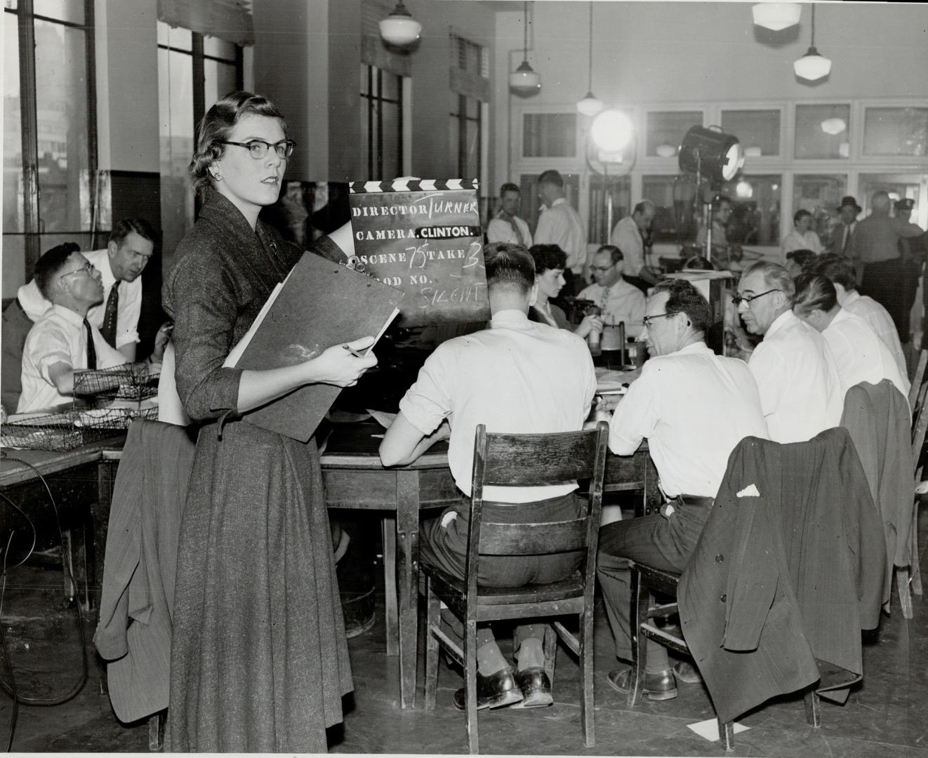 Script girl holds board identifying shot as camera prepares to film The Star's city room, where all news copy is edited