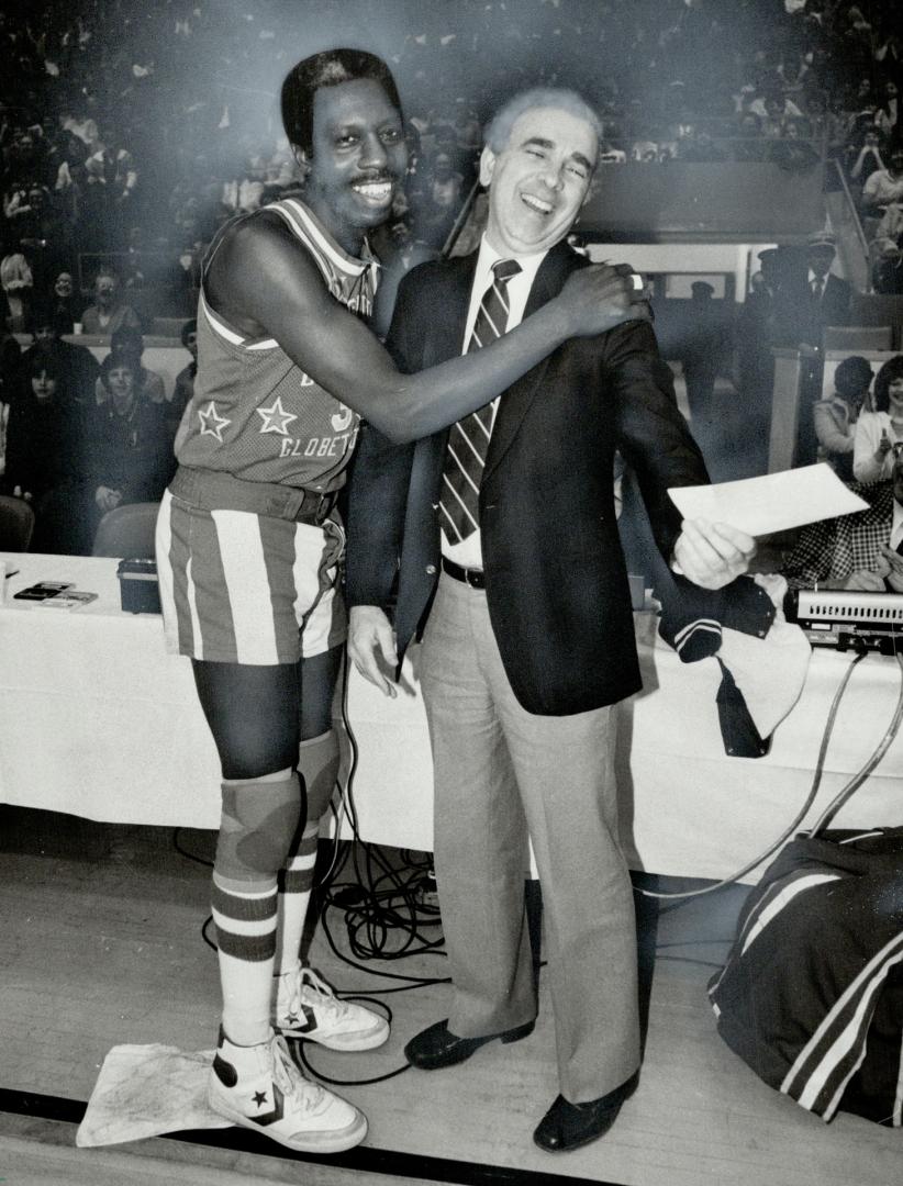 Harlem Globetrotter Geese Ausbie gives Tom Murtha, vice-president of marketing and sales for The Star, the promise of a cheque for The Star Fresh Air Fund, based on a portion of gate receipts