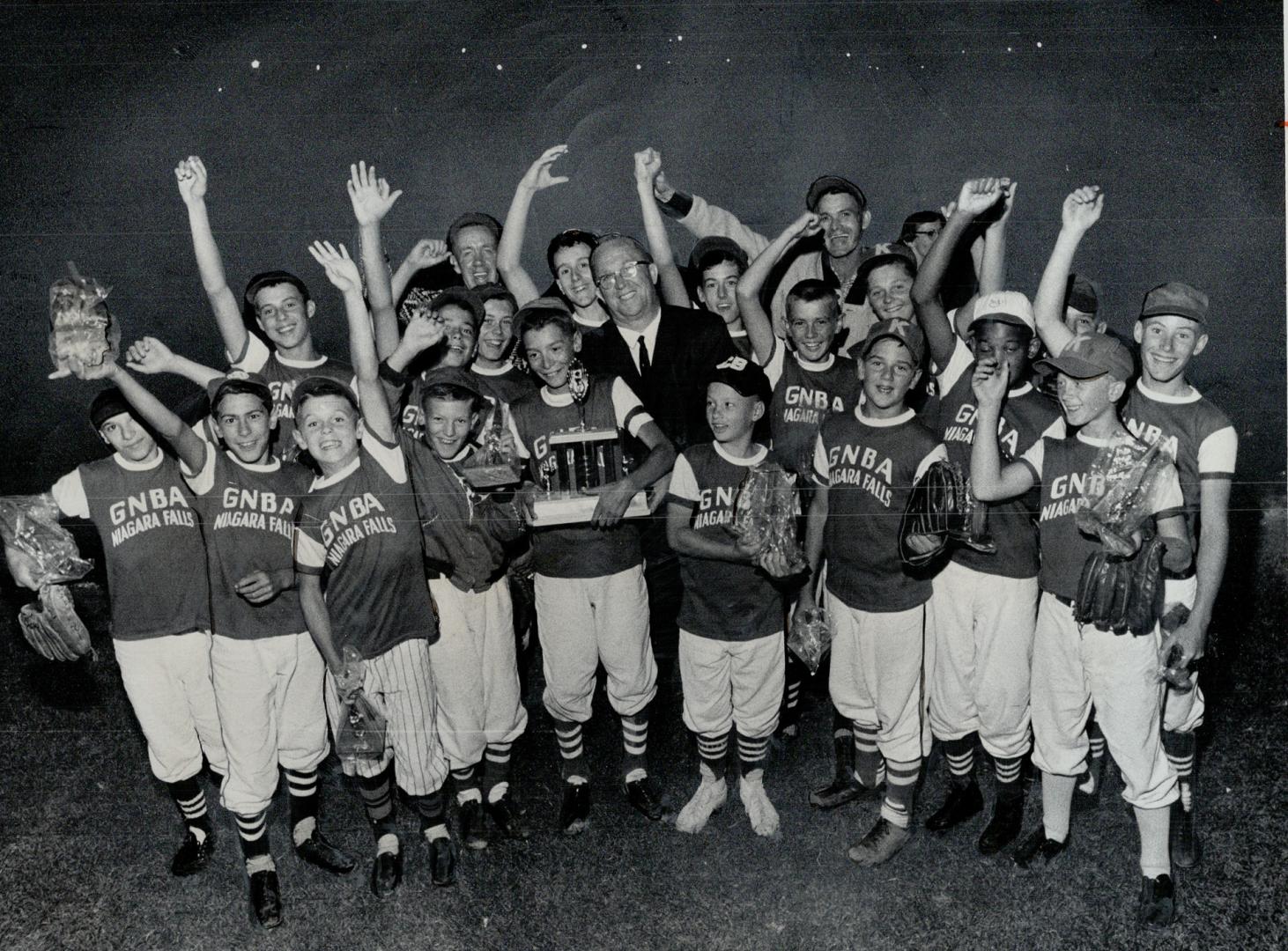 Hank Sinclair, chairman of Star-CNE Little Big League peewee baseball tournament, is surrounded by cheering players as he presents Daily Star trophy t(...)