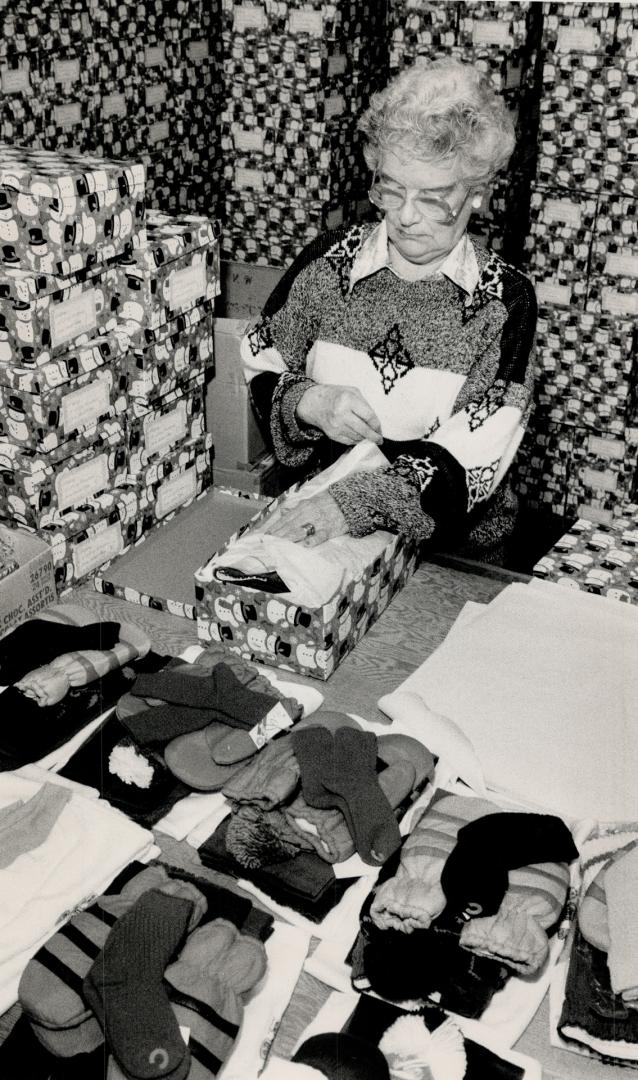 Santa's helper: Marjory Elliott adds her touch to a christmas gift box destined for a needy youngster