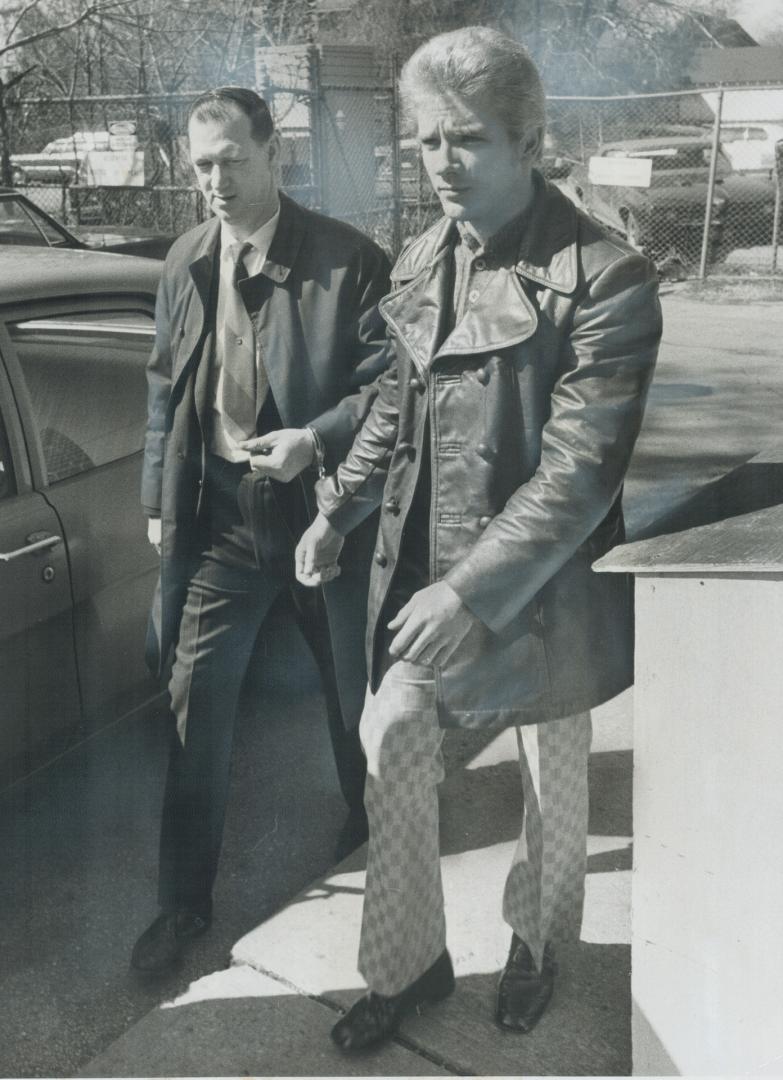 Handcuffed to detective Ron Bird (left), 25-year-old William Lawrence Olenyk enters Willowdale court today after arrest in connection with a series of(...)