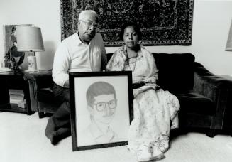 Kumar and Kavita Berry hold photo of son Sharad