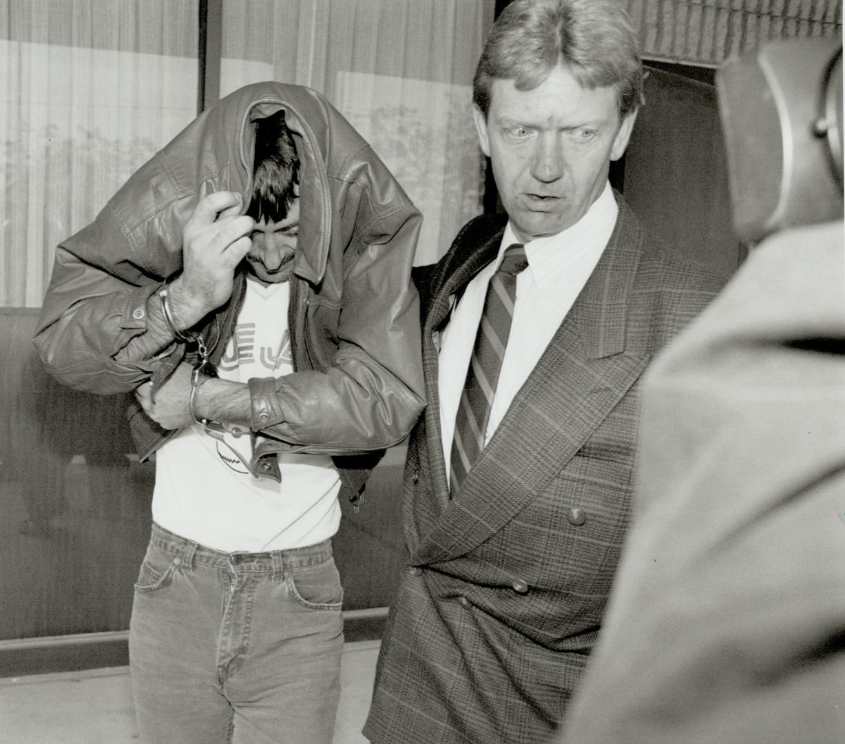 Leaving courthouse: James Leslie Anderson, 322, covers his face as he and an OPP officer leave the Gueiph courthouse after his bail hearing was put over