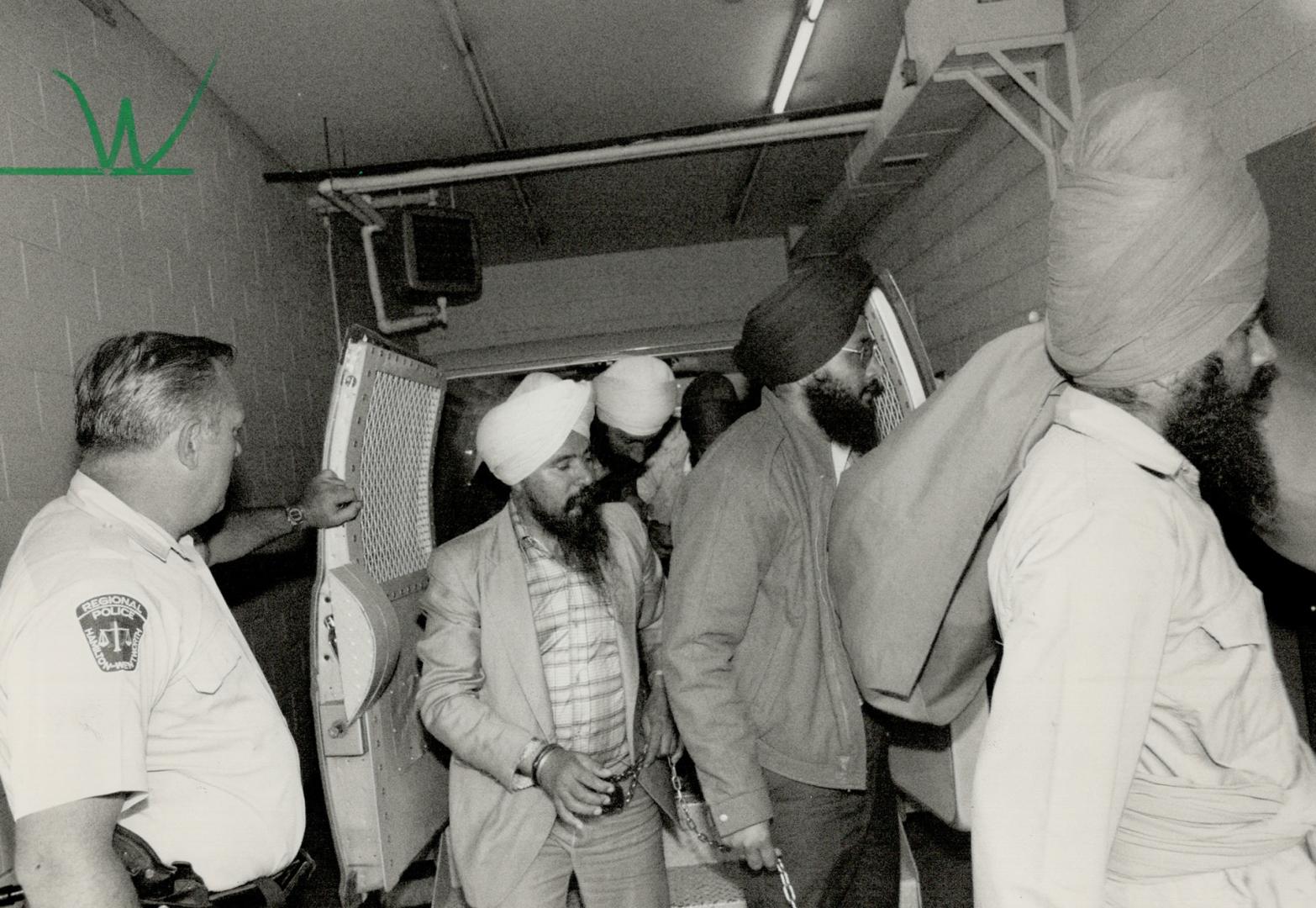 Arriving for hearing: Six manacled Sikhs are brought from paddy wagon to the provincial court where they appeared on charges of plotting terrorist activity