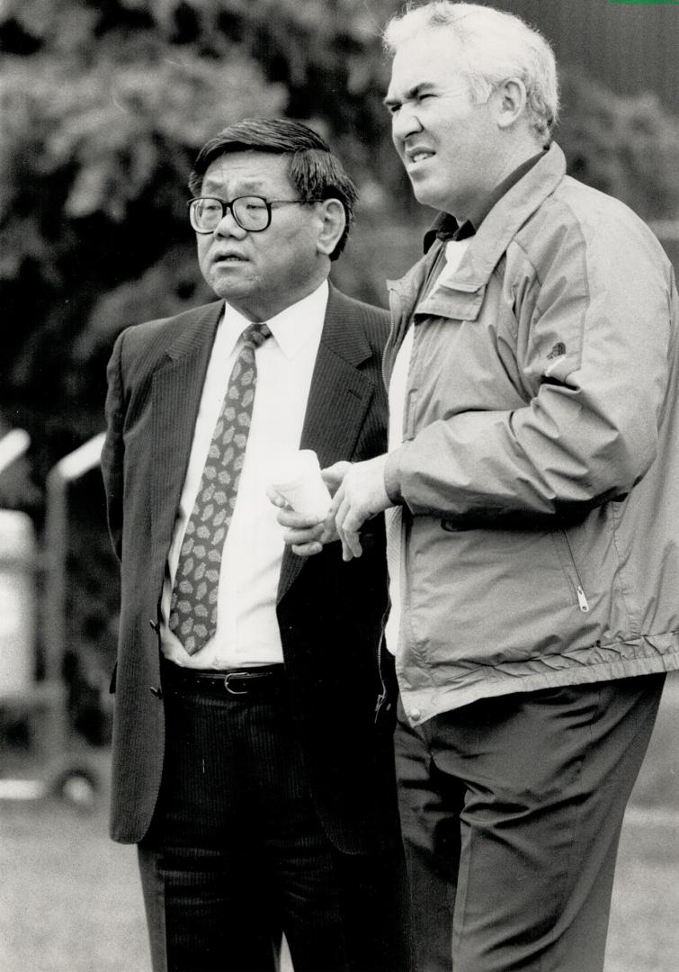 Star Gazing? CFL president Bill Baker, right, and Calgary Stampeders president Normie Kwong fervently hope many more fans will join this lonesome one (left) in the stands at McMahon Stadium