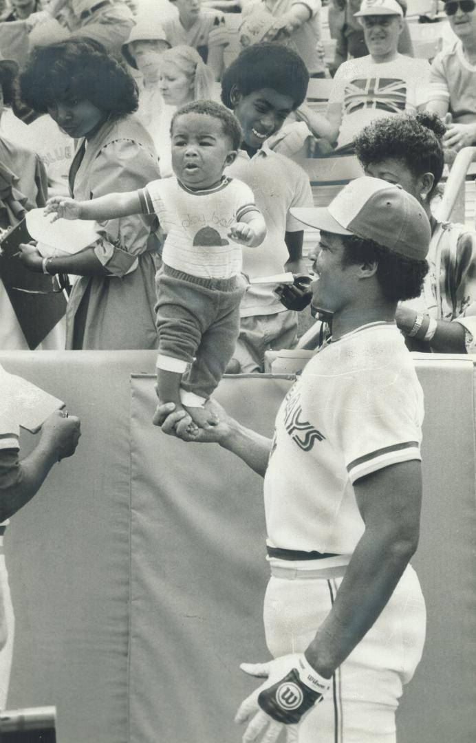 Dad makes a one-hander! Blue Jays' outfielder Jesse Barfield gave more than the fans a lift yesterday