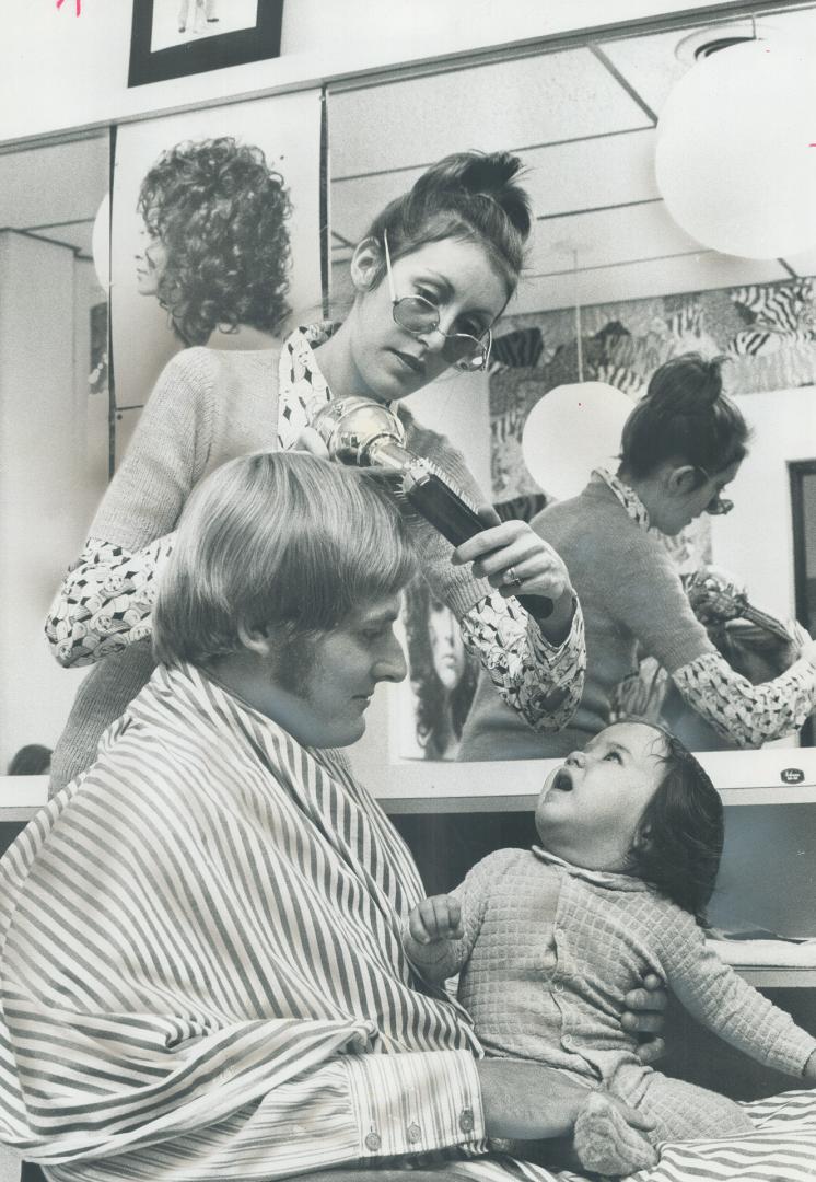 An Argo gets clipped. Toronto Argonaut football player Greg Barton does a little baby-sitting as he holds 8-months-old Sara MacDonald as mother, Mrs. (...)