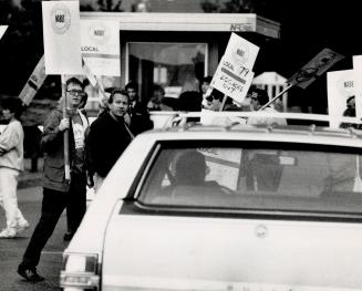 Running the gantlet: CFTO-TV president Douglas Bassett is a passenger in a car waiting this morning to be escorted through unionized workers locked out by management