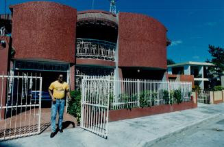 George Bell stands in front of his home where friends, like Alfredo Griffin and Joaquin Andujar, drop in