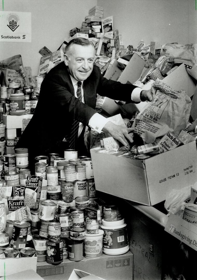 Gordon Bell, Scotiabank president, looks over some of the 6,000 pounds of food collected by bank employees for the Daily bread food bank