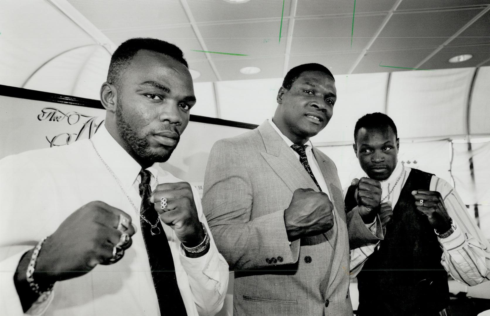 Tough guys. Former world heavyweight champ Trevor Berbick, centre, displays the weaponry he will take into the ring July 9 in Toronto. The two guys be(...)