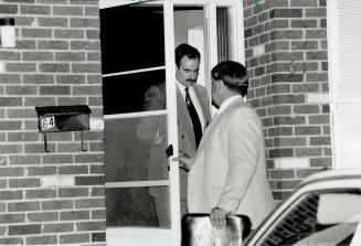 Sad duty: Inspector Vince Bevan, in dark suit, and Sergeant Murray MacLeod leave Anderson house