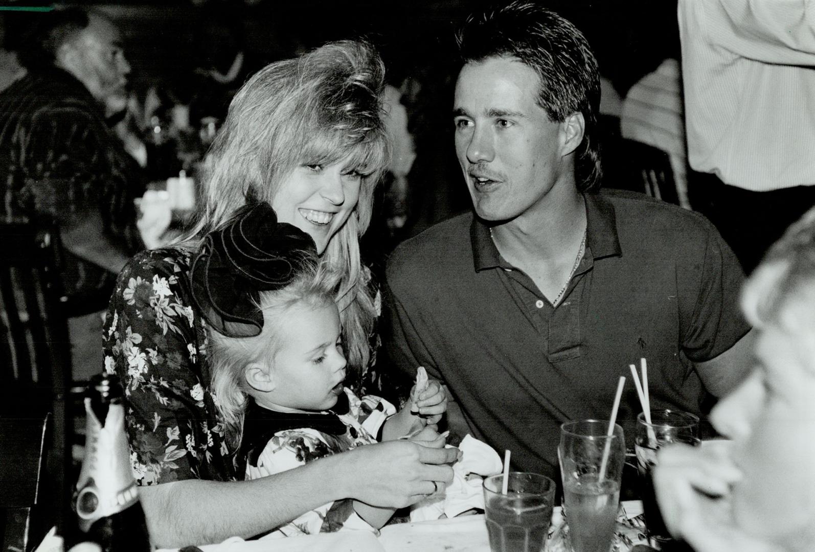 Apres win: Blue Jays catcher Pat Borders, wife Kathy and their daughter Lindsay, 22 months, enjoy a meal after Toronto clinched a division title yesterday