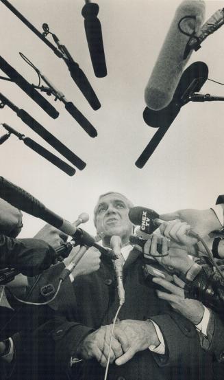 Facing the press: Enveloped in a cage of microphones, New Democrat leader Ed Broadbent answers reporters questions outside party headquarters in Oshawa yesterday