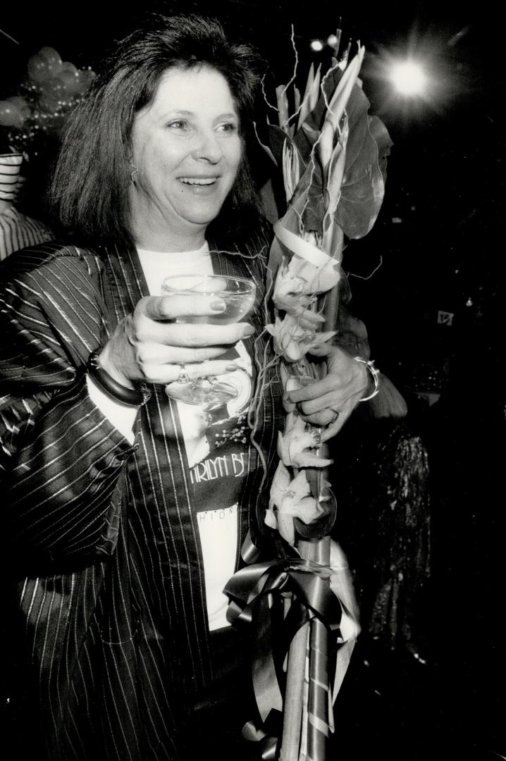 Designer Marilyn Brooks toasts the crowd from the runway during the celebration of her 25th anniversary in fashion