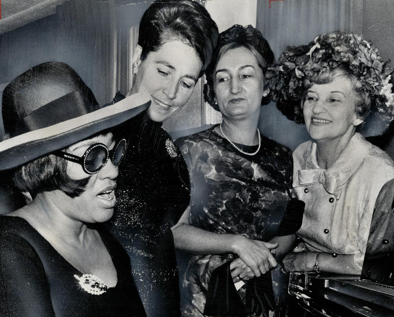 Singing a travel theme. Jazz singer Olive Brown taught International Co-operation year travel song to Mrs. J. G. Rowland, left, Mrs. Krystina Grotowsk(...)