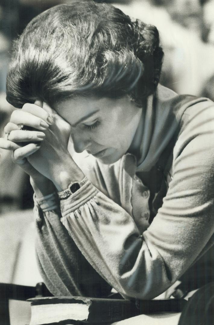 Crusader Anita Bryant bows her head in prayer during a visit to Toronto yesterday