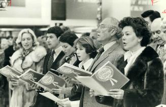 Maintaining a store tradition, members of the Burton family join the carolling this morning with customers and staff