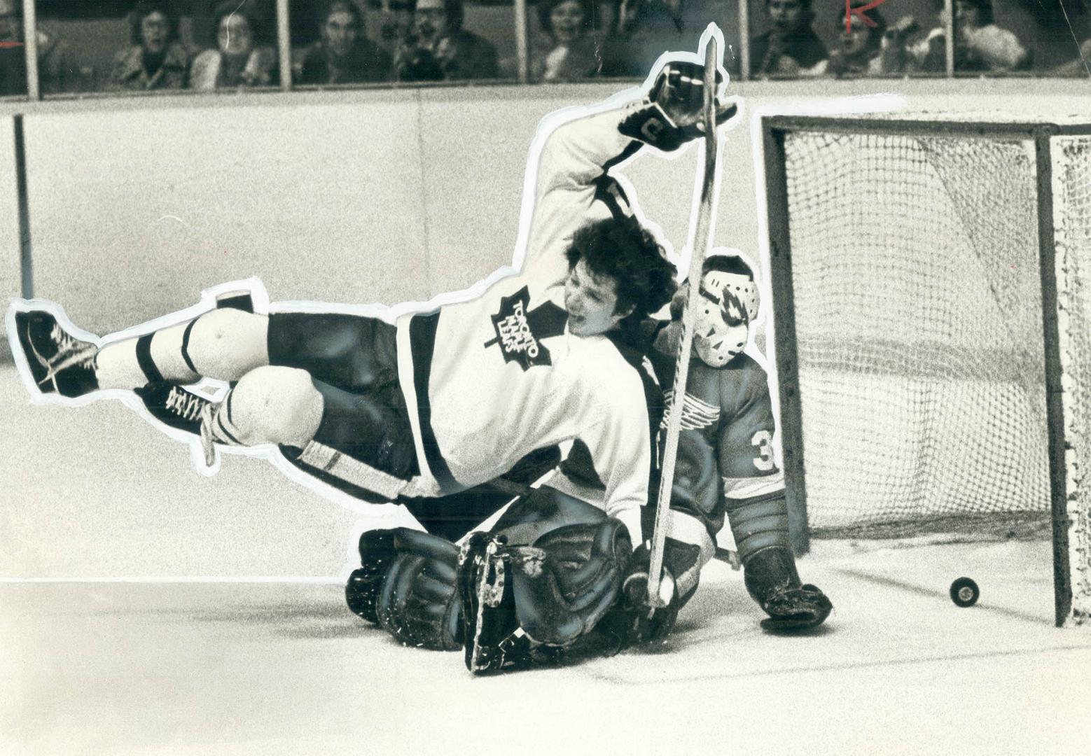 Leafs' Jerry Butler crahses into Wing goaltender Ed Giacemin as puck crosses line into net