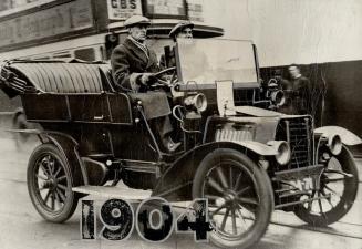 Sir Malcolm Campbell, long holder of the world's speed record, at the wheel of an early 1904 English automobile