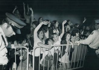 Agony and ecstacy as a fan is scrunched up against the barrier but gets a glimpse of David Cassidy