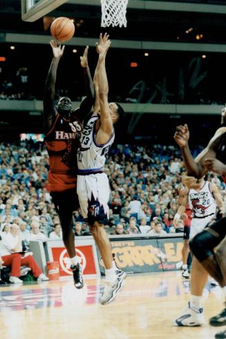 Up, Up and Away. Raptors guard Doug Christie tries his hardest to stop hard-charging Hawk Tyrone Corbin from making basket last night at SkyDome