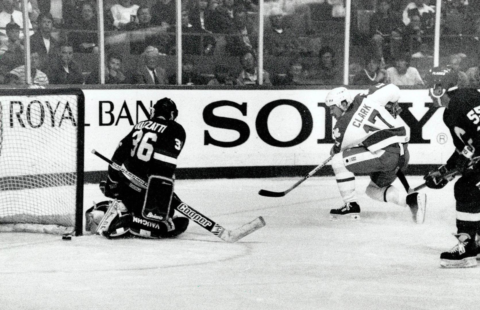 In it goes: Wendel Clark slips the puck under Flames metminder Jason Muzzatti during the Leafs' 3-1 pre-season win over the Flames last night at the Gardens