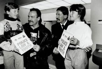 Police get assist from Wendel. Toronto Maple Leaf captain Wendel Clark and OPP Sergeant John Mason present Newmarket 9-year-olds Scott Stables, left, (...)