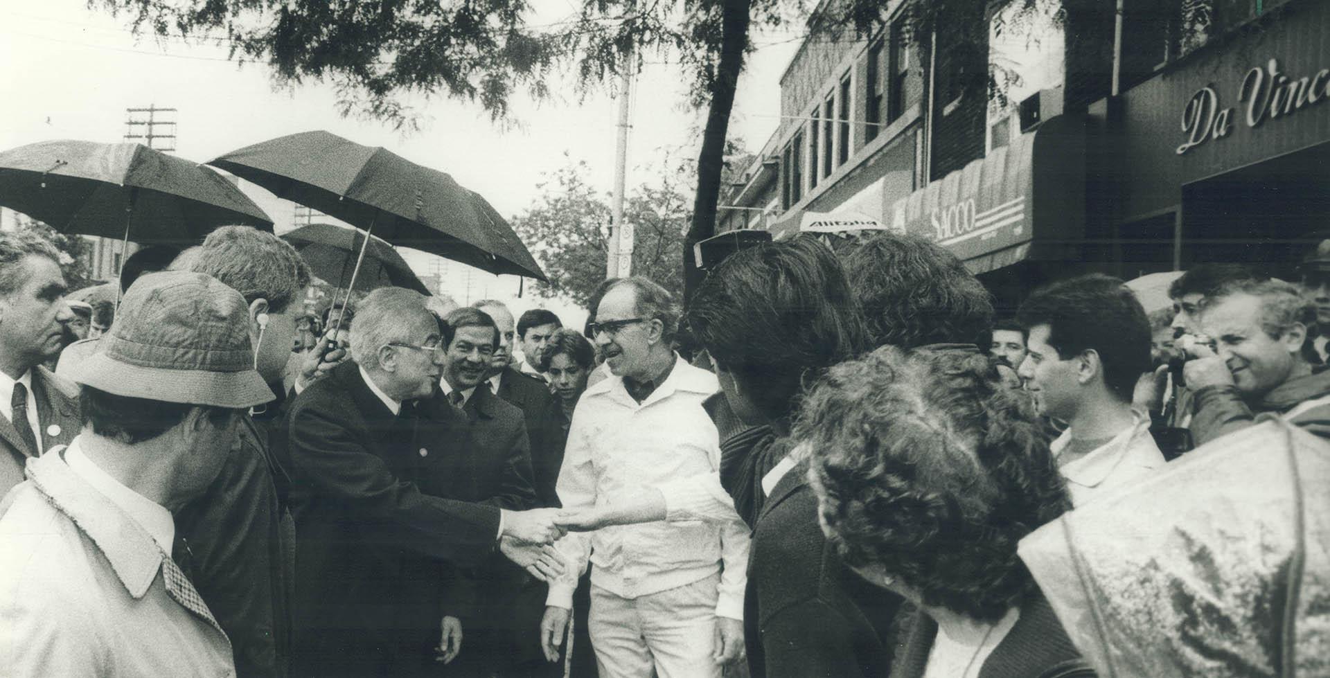 Image shows a President surrounded by a crowd of people in the streets.