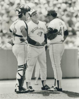 Manager Bobby Cox, with catcher Ernie Whitt to his right, is at the mound to yank Luis Leal in the third inning after the pitcher had given up five runs to add to the three he allowed in the first