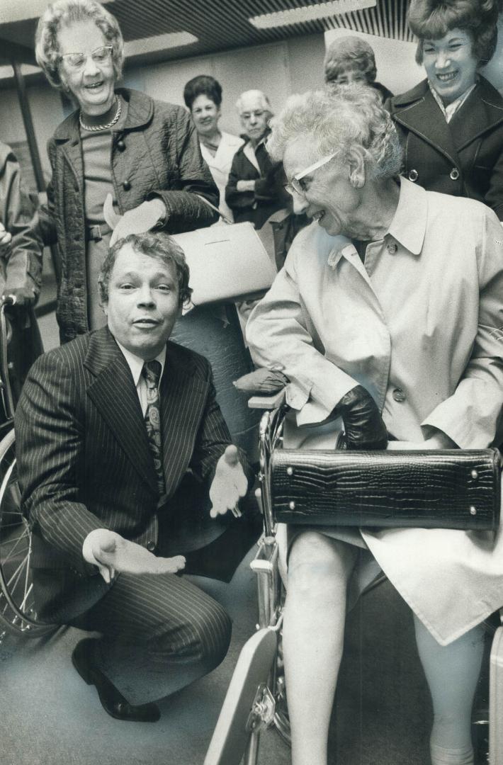 Toronto Mayor David Crombie crouches to talk with Gladys Bannister, 75, one of 20 senior citizens, eight of them in wheelchairs, at City Hall yesterda(...)