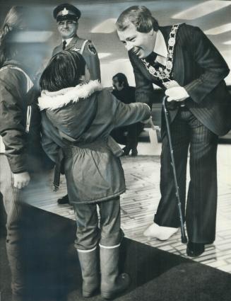 Foot still in cast after being broken several weeks ago, Mayor David Crombie greets 6-year-old Kathy Lee at New Year's levee yesterday. Later, he lear(...)