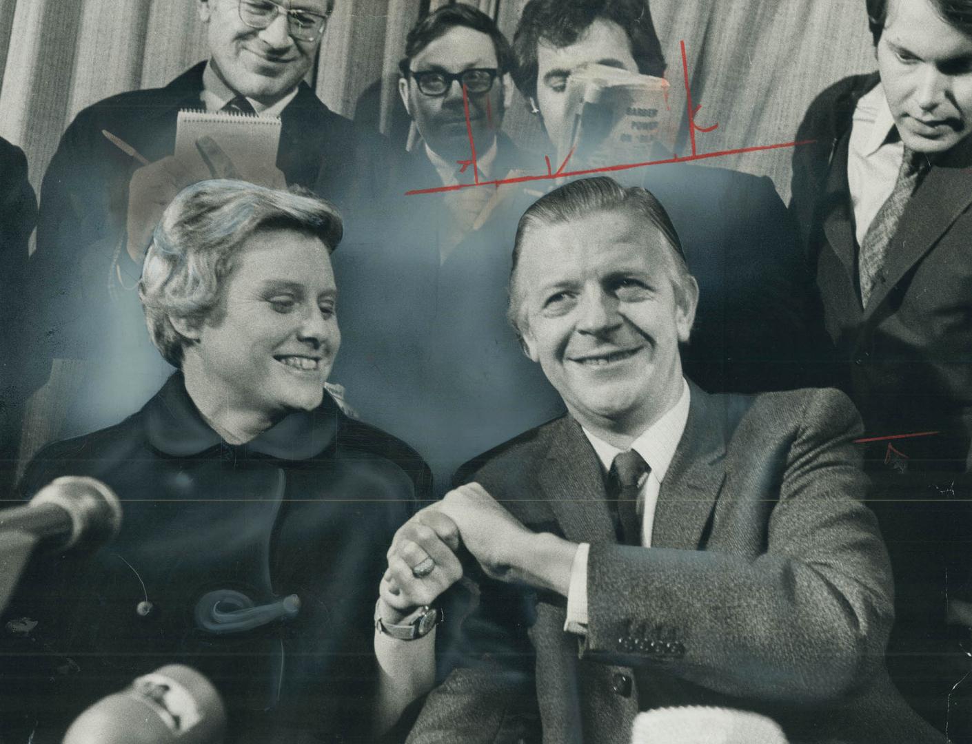 Holding hands happily, British diplomat James Cross, reunited with his wife, Barbara, smiles as he makes statement to newsmen at London's Heathrow Air(...)