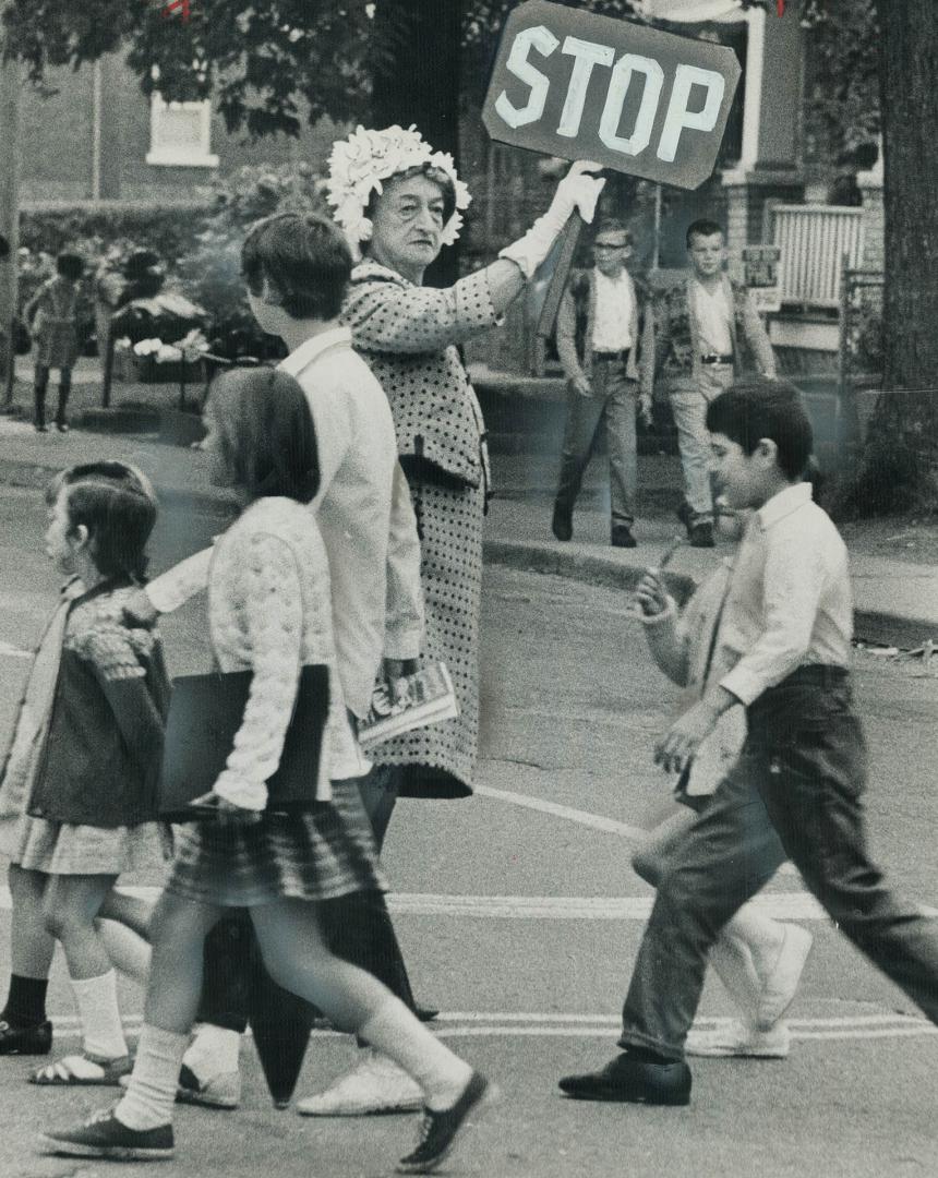 Crossing guard is their mayor. East Yok Mayor True Davidson holds up homemade sing to stop cars so children can cross road to Secord Public School Tod(...)