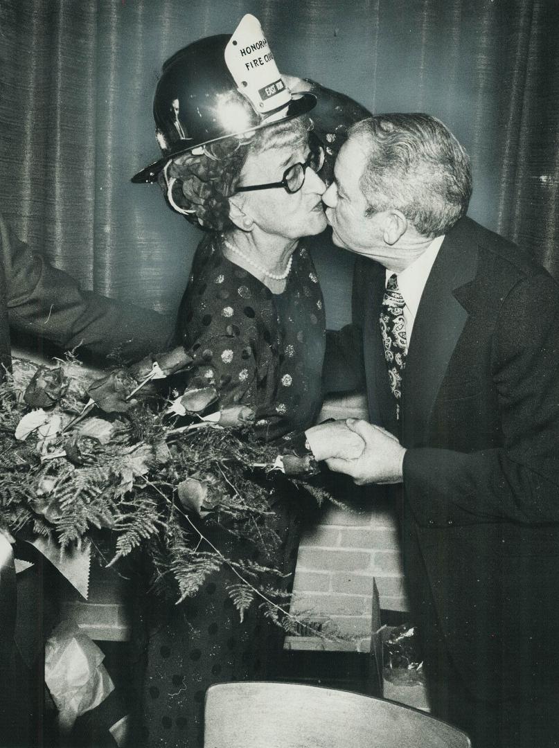 True's now a fire chief. Retiring Mayor True Davidson of East York kisses East York Fire Chief Ernest Bell last night after he had presented her with (...)