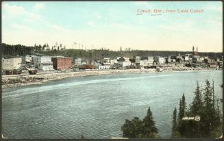 A medium sized mining town sits beside a large lake.