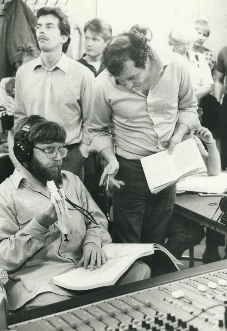 At the controls: Conductor Andrew Davis munches on a banana while conferring with Planets producer Anton Kwiatkowski